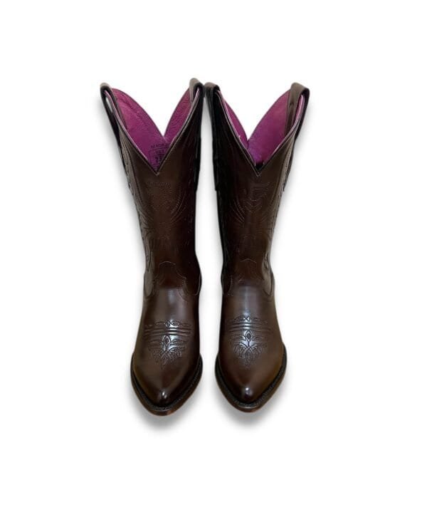 Botas de cowboy de cuero marrón con detalles ornamentales y forro rosa brillante, ideal para estilo western y moda rural. Perfectas para occasions al aire libre y eventos temáticos cowboy.